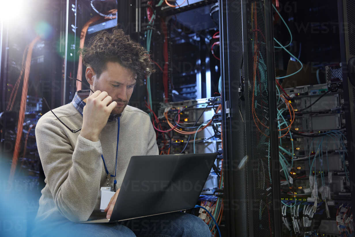 focused-male-it-technician-using-laptop-in-server-room-CAIF07394